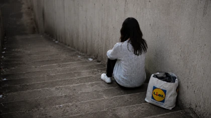 Woman sitting on stairs, seen from behind