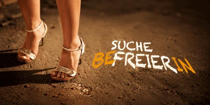A woman in gold high heels with the words “Seeking a Liberator” .