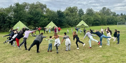 Menschen stehem im Kreis und machen Übungen